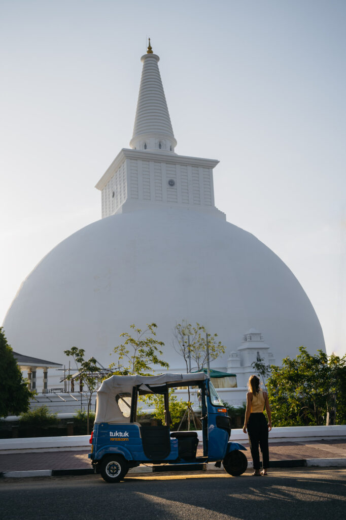 A CabrioTuk parked next to a beautiful temple in Anuradhpura