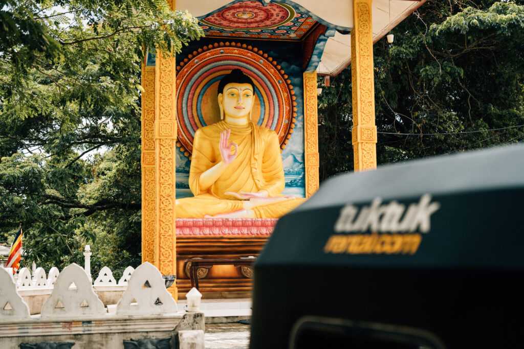 In the realm of spirituality - Embrace the tranquility of the moment as a tuktuk crosses paths with a peaceful Buddhist temple in Kandy