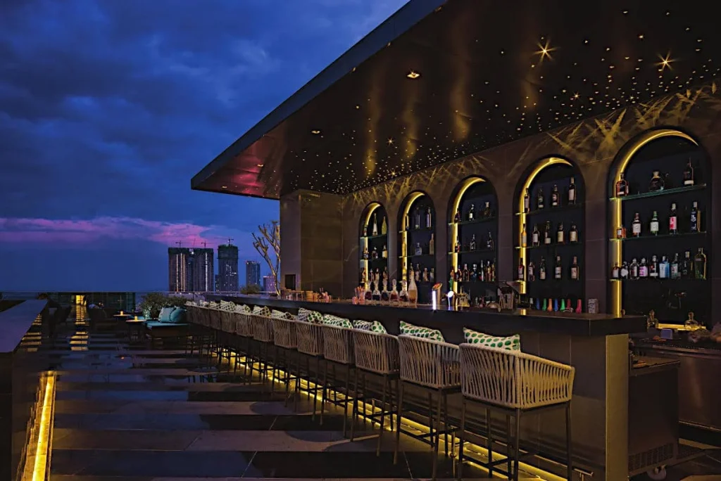 Modern rooftop bar with starry ceiling lights.