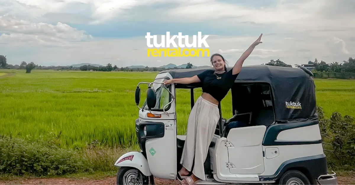 Happy woman posing in tuk-tuk near rice fields.