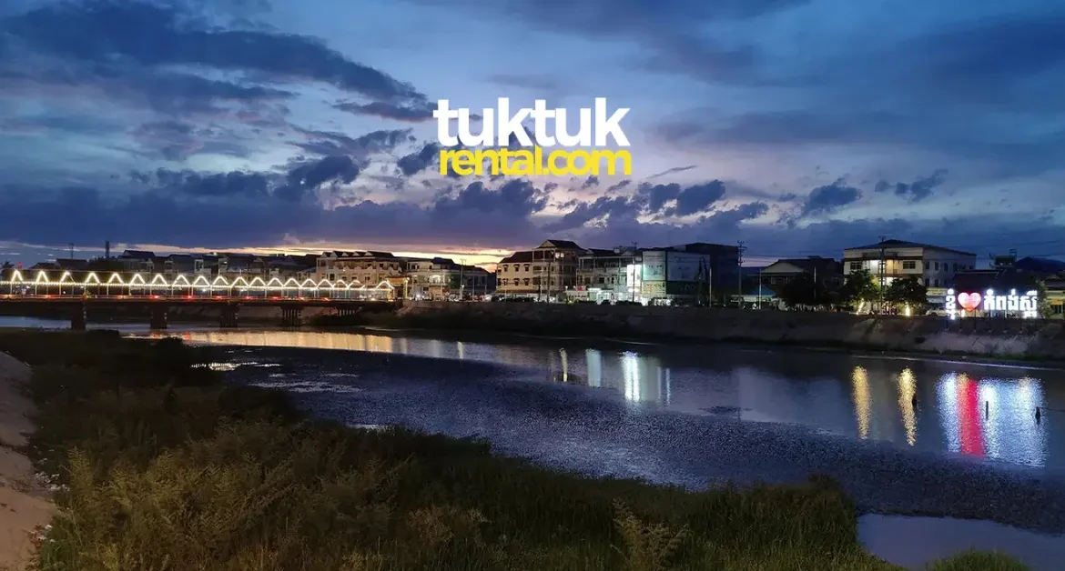 City lights reflecting in river at dusk.
