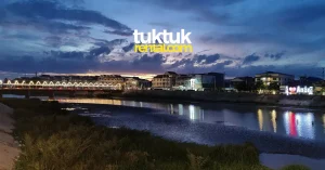 City lights reflecting in river at dusk.