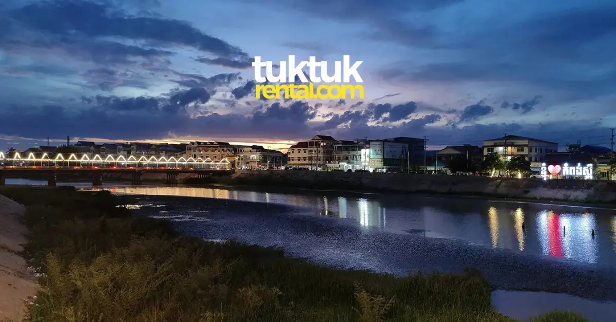City lights reflecting in river at dusk.
