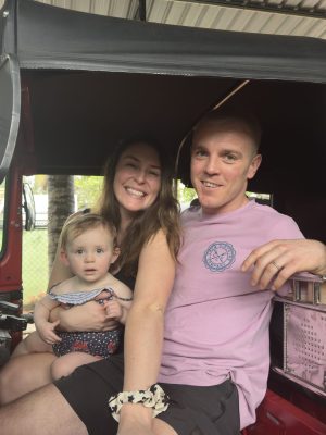 A family of three riding in a tuk-tuk.