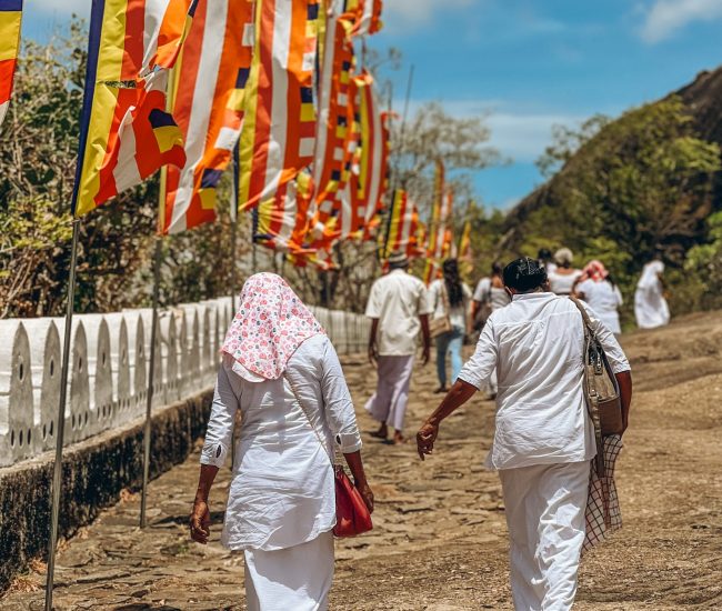 A couple walks beside flags.