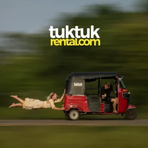 an image of a female tourist hanging on to a moving tuktuk from the back while a male tourist drives the tuktuk