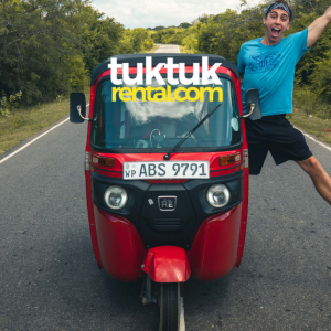 A red tuk-tuk with a person standing next to it.