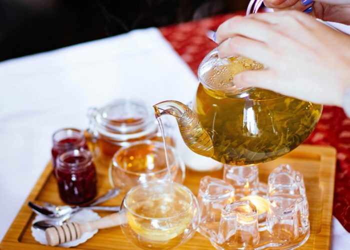 A person is pouring plain tea into a cup.