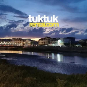 City lights reflecting in river at dusk.